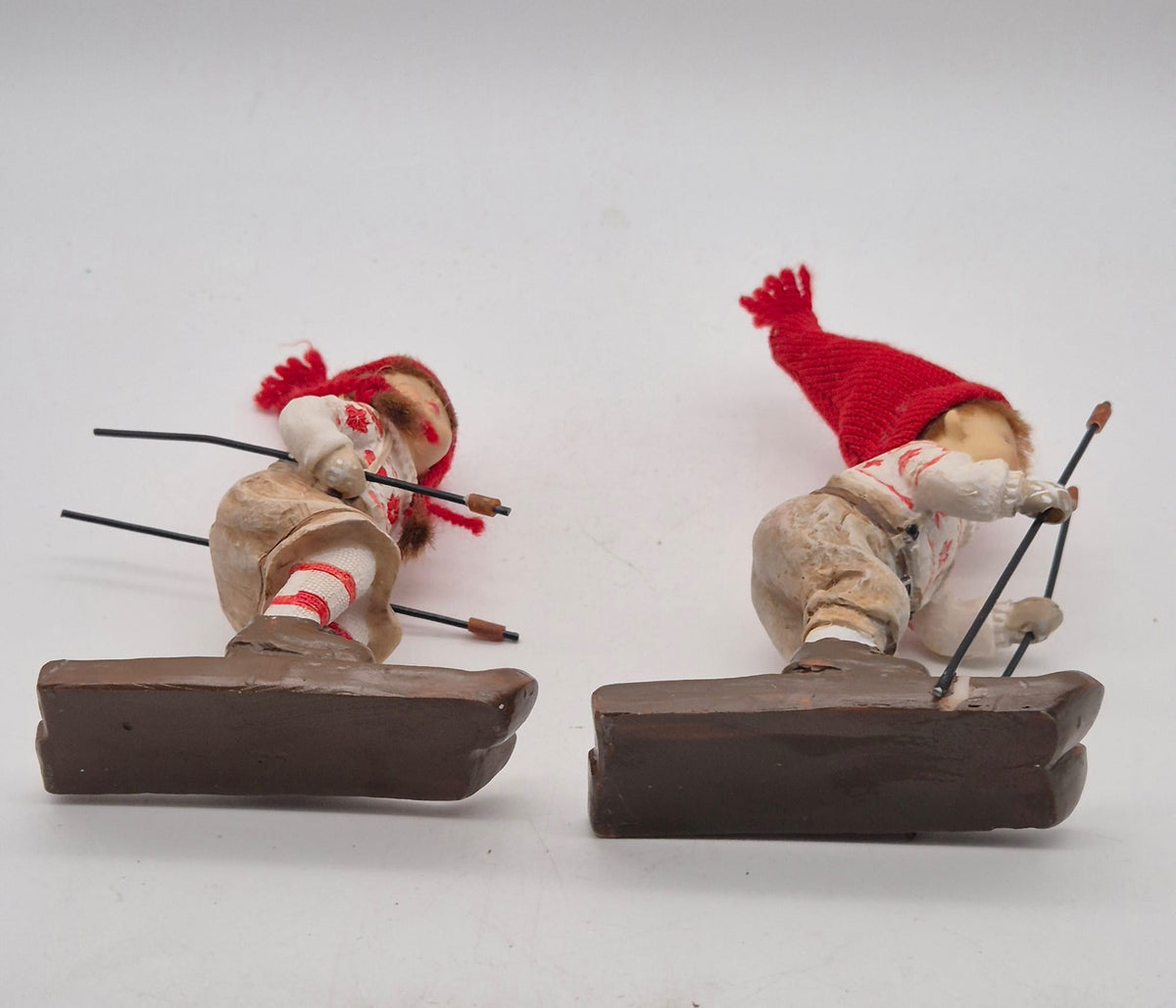 2 Winterkinder auf Skiern – Mädchen und Junge mit roten Strickmützen – Polyresin – ca. 16 cm