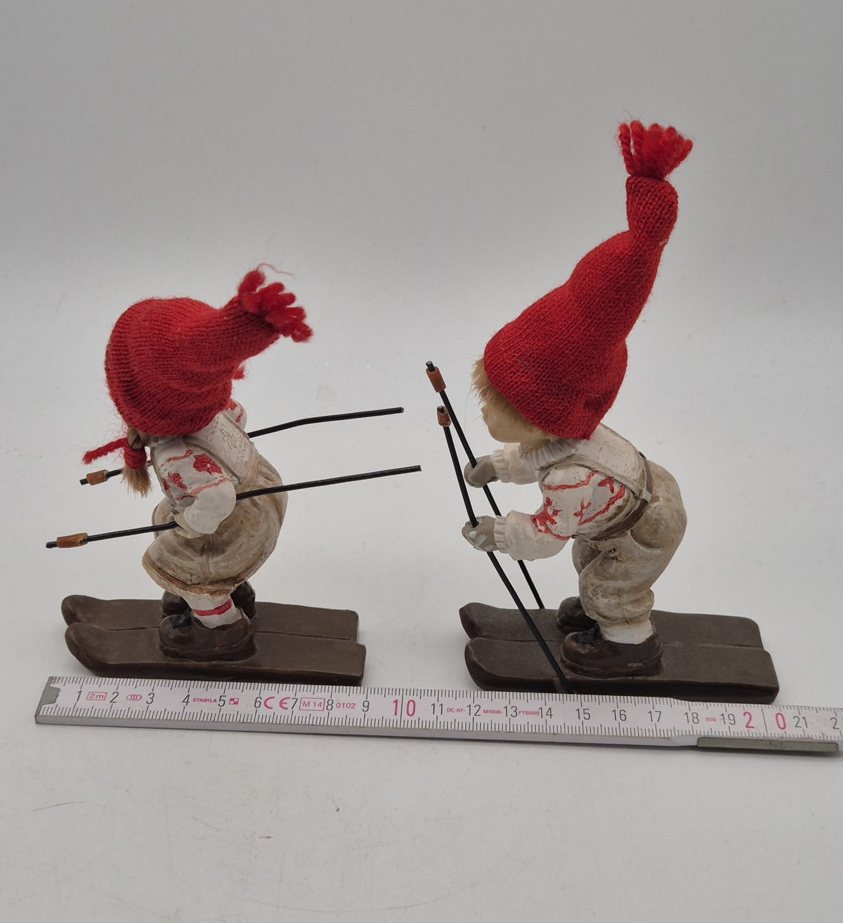 2 Winterkinder auf Skiern – Mädchen und Junge mit roten Strickmützen – Polyresin – ca. 16 cm