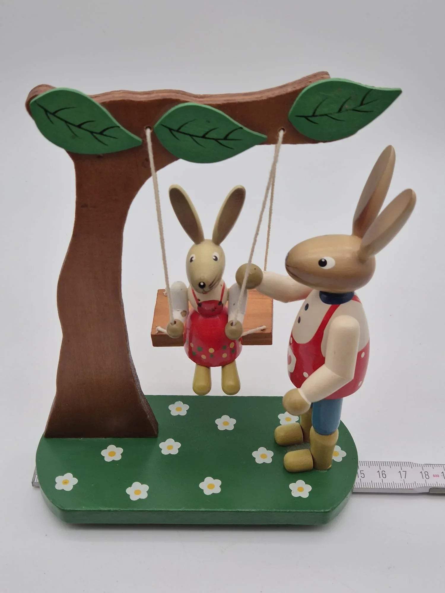Hasenfigur Vater mit Kind auf Schaukel unter Baum Holz