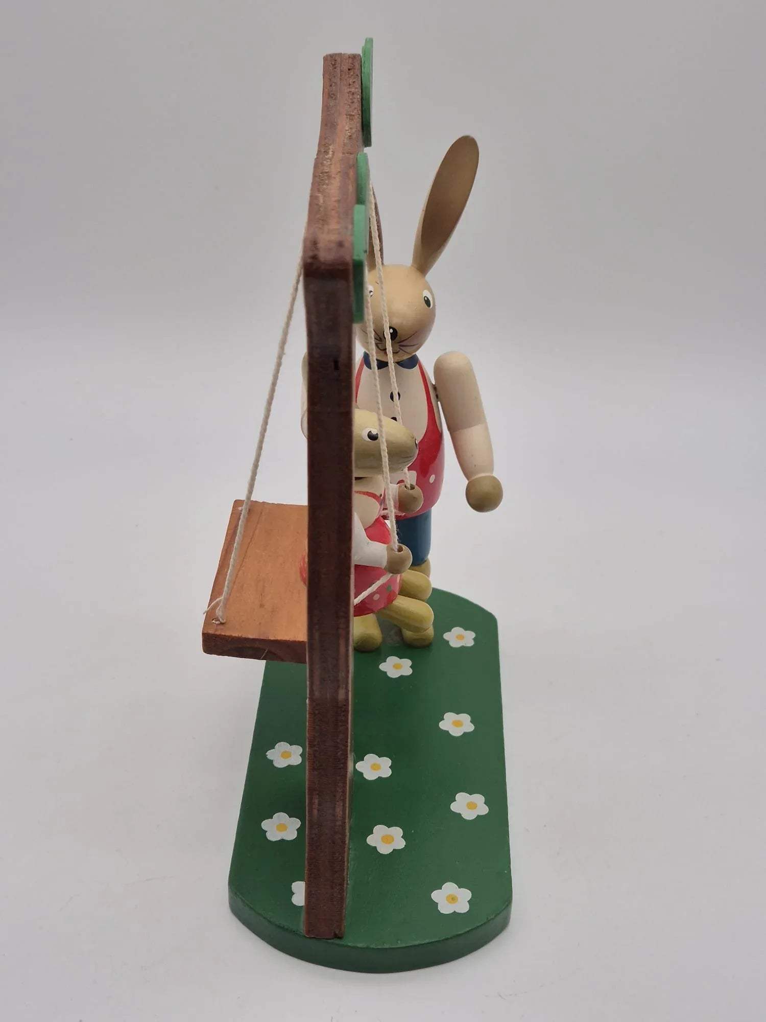 Hasenfigur Vater mit Kind auf Schaukel unter Baum Holz