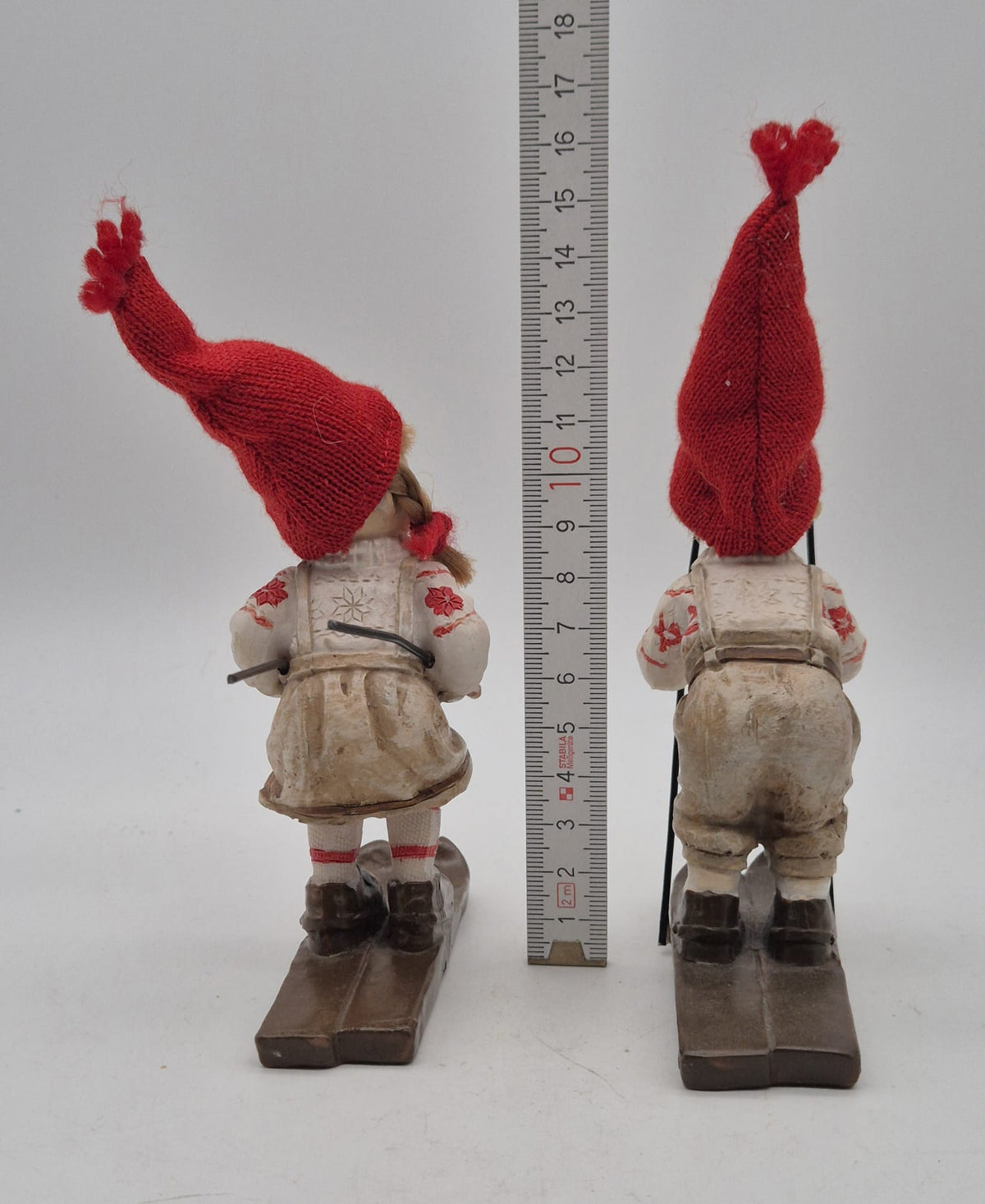 2 Winterkinder auf Skiern – Mädchen und Junge mit roten Strickmützen – Polyresin – ca. 16 cm