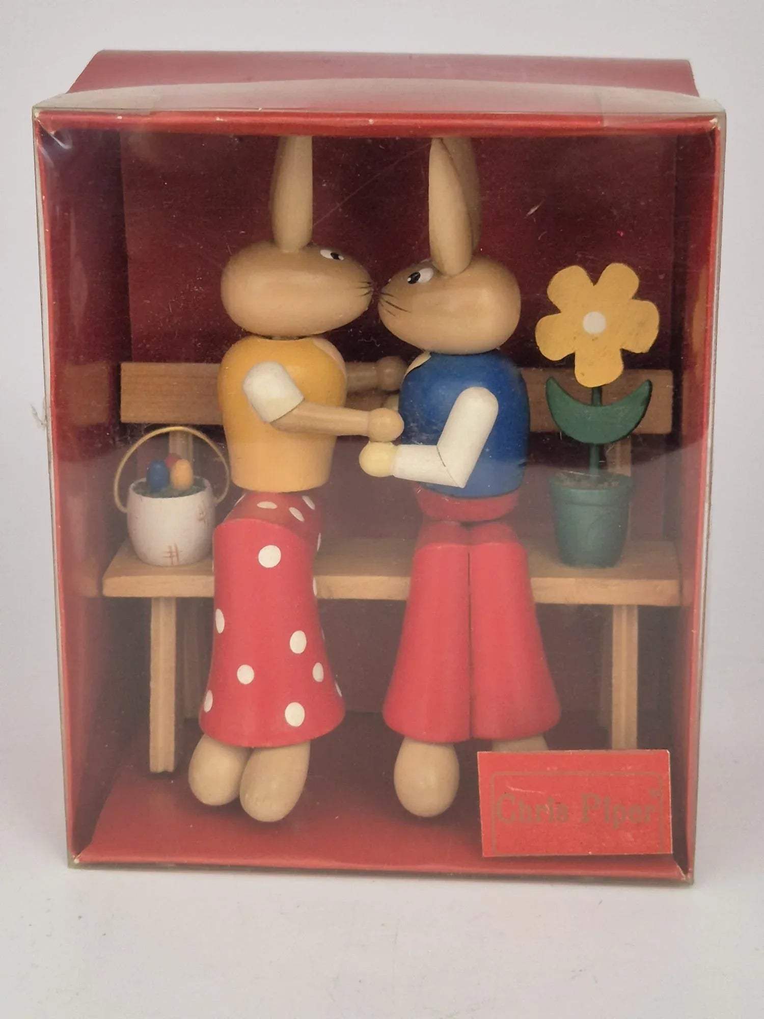 Holz Osterhasen-Paar auf Bank – mit Blume & Eierkörbchen – ca. 13 cm