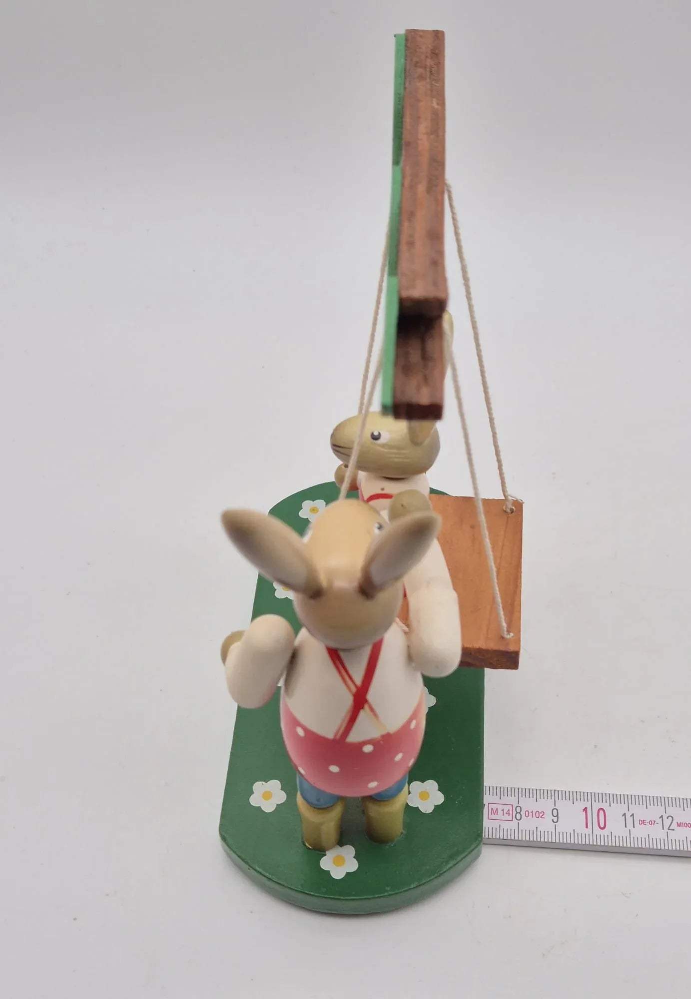 Hasenfigur Vater mit Kind auf Schaukel unter Baum Holz