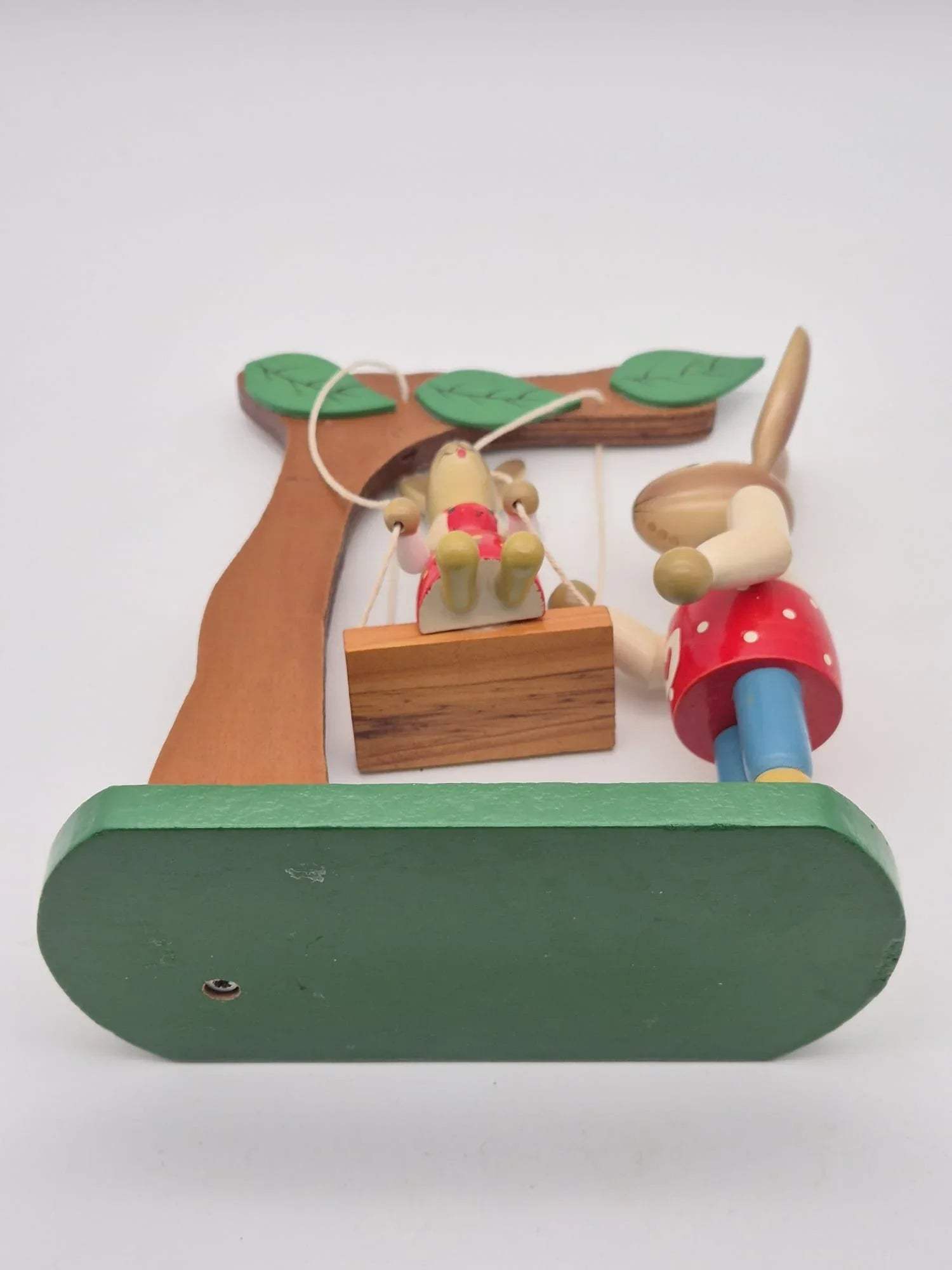 Hasenfigur Vater mit Kind auf Schaukel unter Baum Holz
